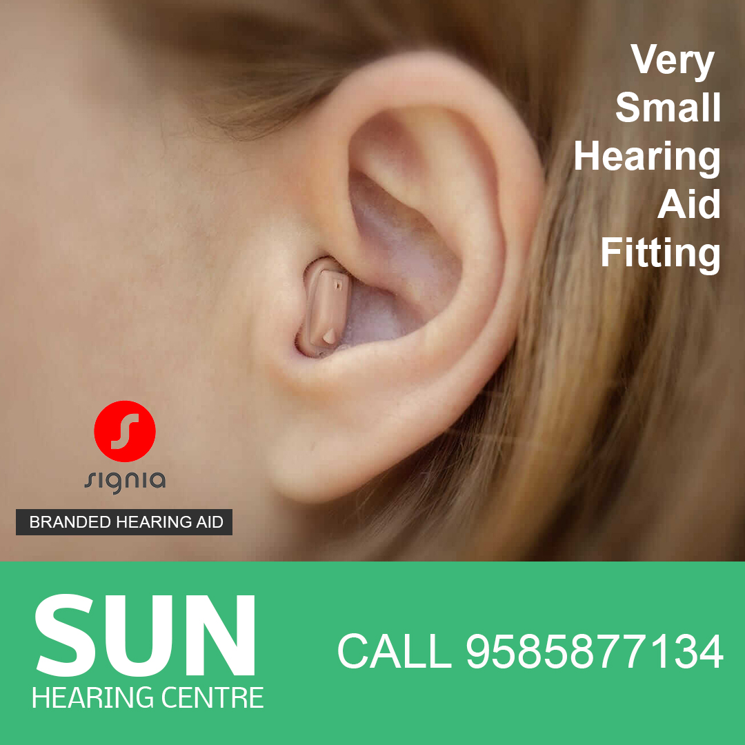 Audiologist fitting hearing aid